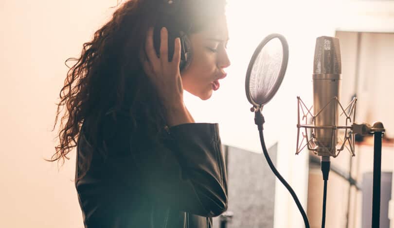 Singer recording vocal tracks in home studio.